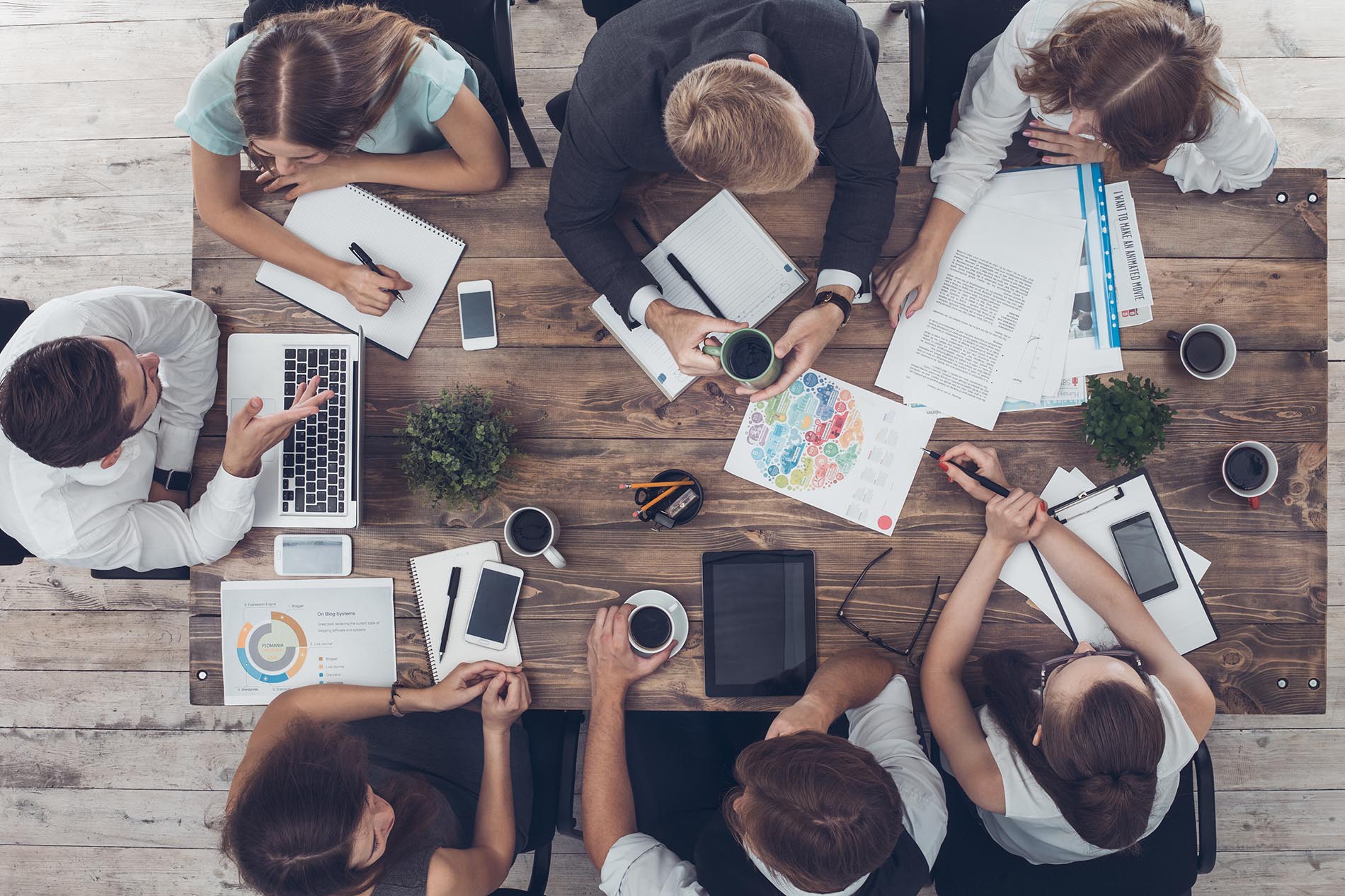 Business people man and women meeting in the office top view using digital device